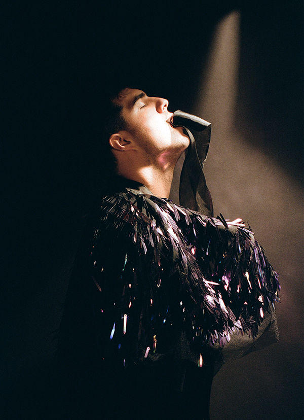 Professional photo of Jeremy Dutcher from his right side, looking upwards with his eyes closed.