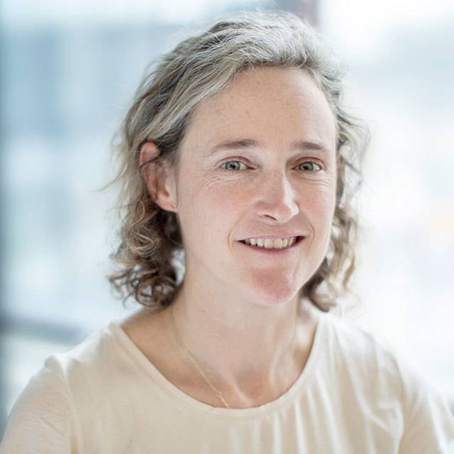 Headshot of Katherine Willis in a light beige top in front of a window.