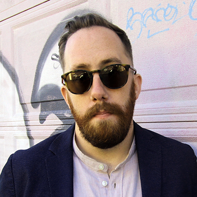 Headshot of Justin Ling in a dark blazer with sunglasses on.