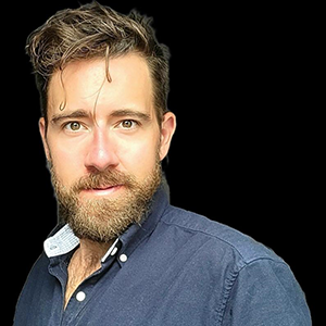 Headshot of Hugh Samson on a black background.