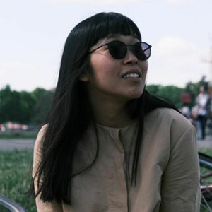 Louise Hisayasu sitting outside with sunglasses on.