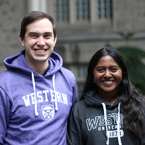 Two students in Western branded clothing smile at the camera