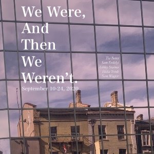 We Were, And Then We Weren’t reflected in the windows of a high-rise