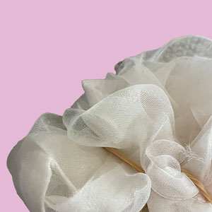 plastic mesh folded and wrapped in a rubber band, bright pink solid background.